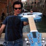 Yup! That’s Venice behind me and my Voyage-Air guitar—a full-size electric guitar that folds in half for travel.