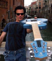Yup! That’s Venice behind me and my Voyage-Air guitar—a full-size electric guitar that folds in half for travel.
