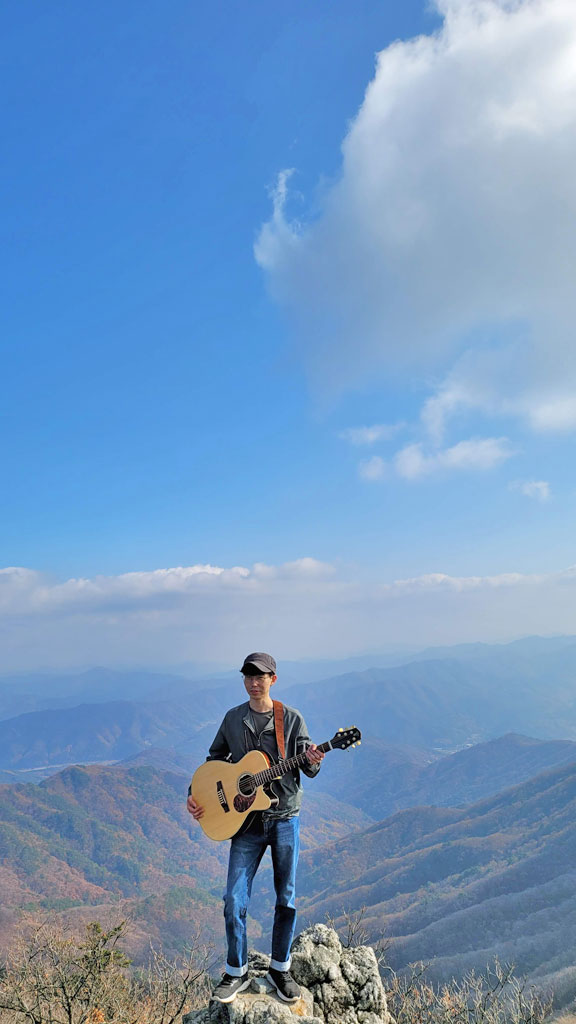 Young Min Yoo Voyage Air Guitar Mountain Top